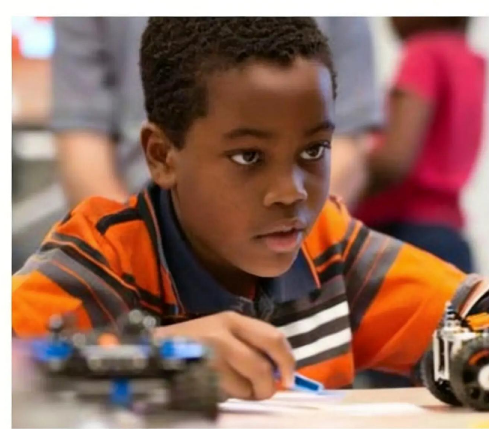 Enfant concentre en atelier robotique